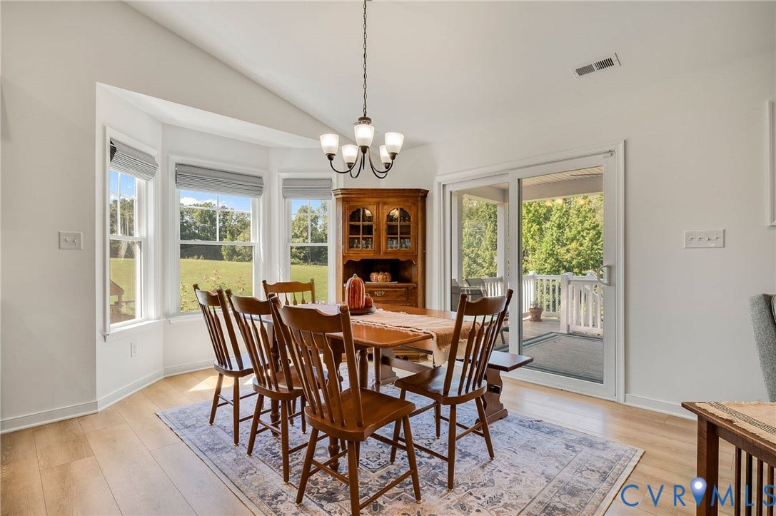 11804 Rydal Way, Cobbs Creek, Glen Allen, VA 23059 Vaulted ceiling with an attached chandelier, wood-finish flooring, bay windows, and a sliding glass door leading to a covered deck