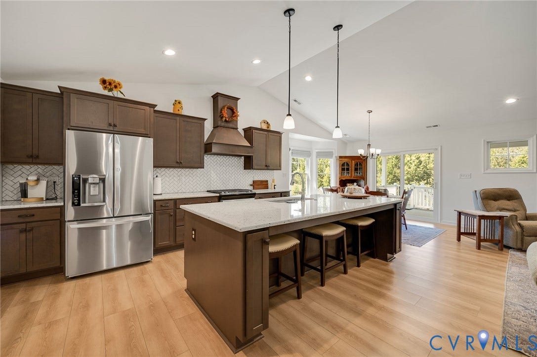 11804 Rydal Way, Cobbs Creek, Glen Allen, VA 23059 Vaulted ceiling kitchen featuring dark wood cabinetry, white herringbone tile backsplash, stainless steel appliances, and wood-finish flooring