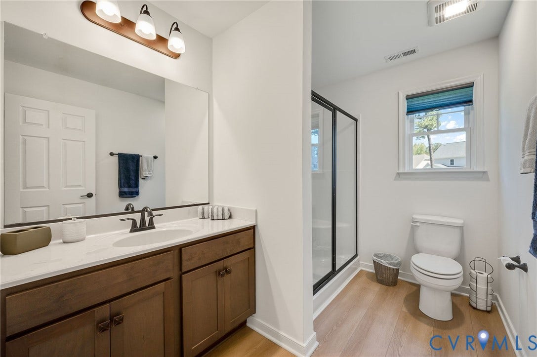11804 Rydal Way, Cobbs Creek, Glen Allen, VA 23059 Double vanity with integrated sink, wood-finish cabinetry, built-in shower with glass enclosure, and wood-finish flooring