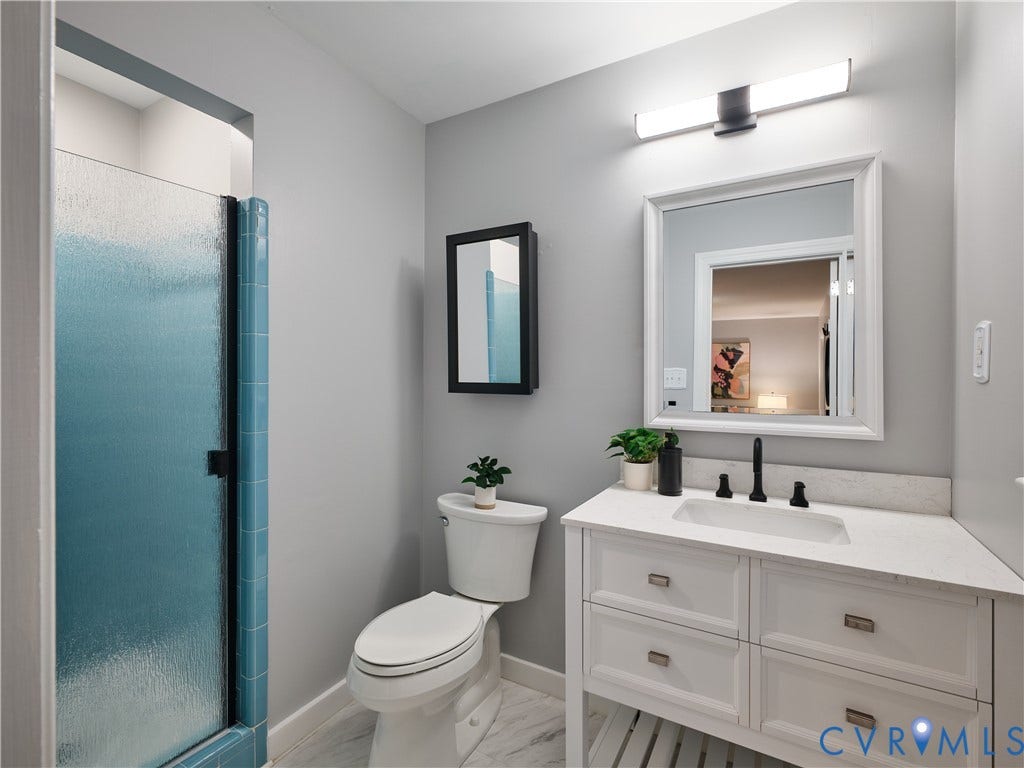 1708 Windingridge Court, Henrico, VA 23238 White vanity with integrated sink and matte black faucet, frosted glass shower enclosure, and modern lighting fixture