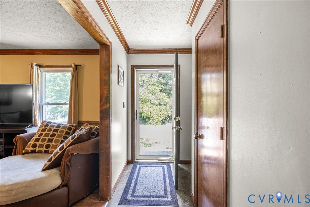 Entryway with a glass-paned exterior door, hardwood trim, and a solid wood interior door