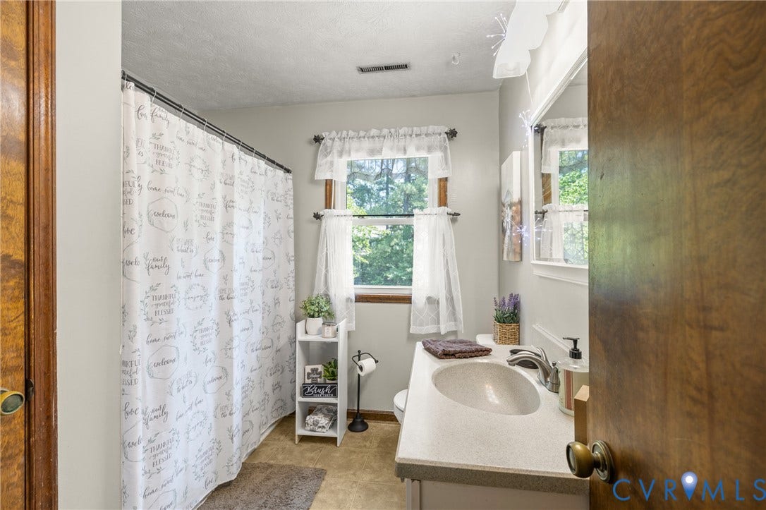 Vanity with integrated sink, polished chrome faucet, and mirrored cabinet