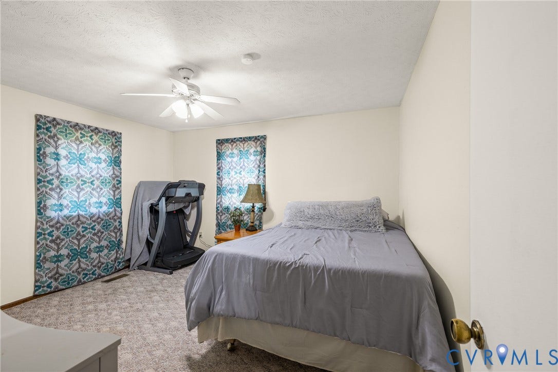 Neutral wall tones, ceiling fan with integrated lighting, and carpeted flooring