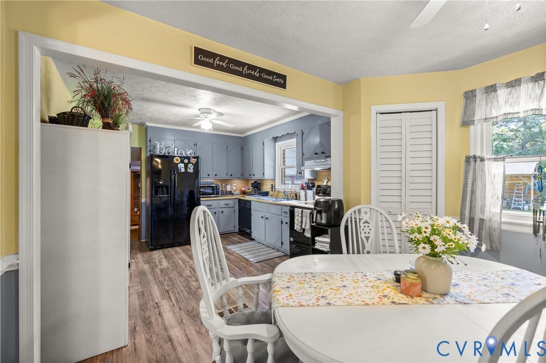 Kitchen area with wood-finish flooring, light-toned cabinetry, and a ceiling fan