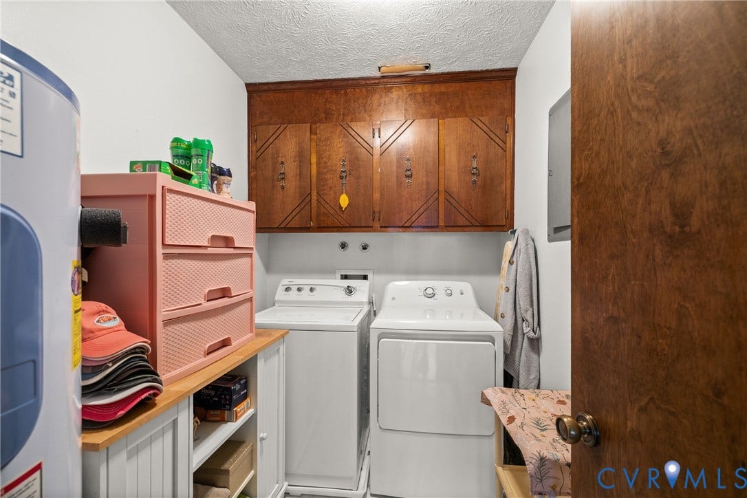 Laundry area featuring wood-finish cabinetry, white wall paint, and beadboard-style lower cabinetry with a wood-finish countertop