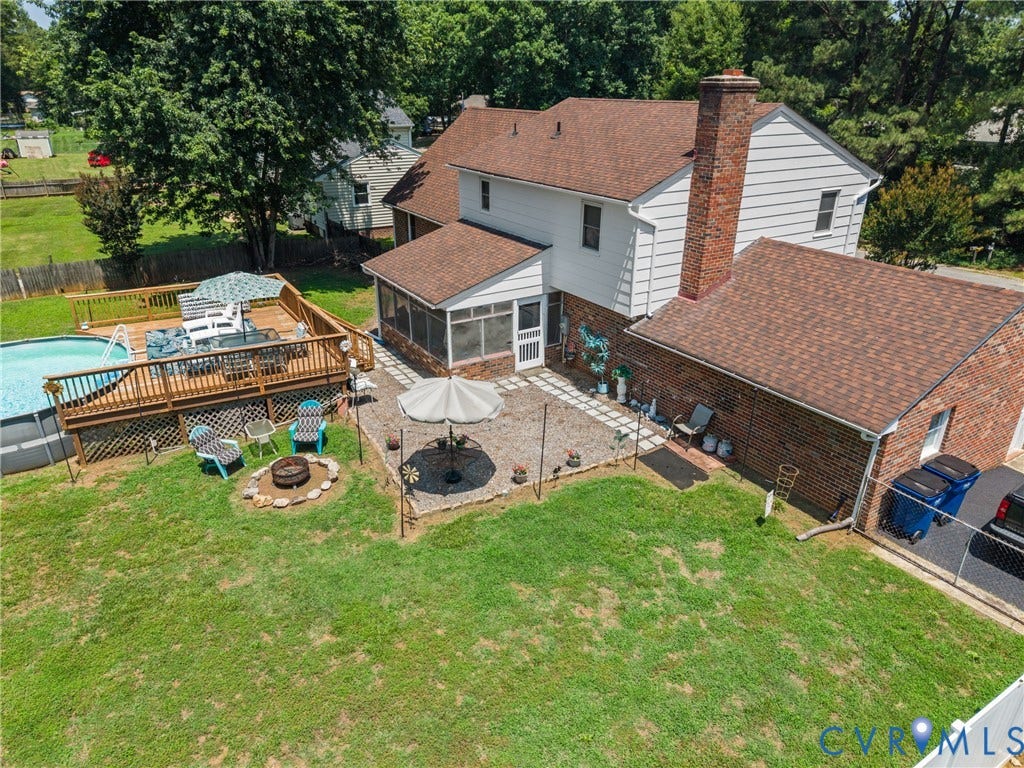 Expansive backyard featuring a multi-level wood deck, above-ground swimming pool, screened porch, and a brick patio