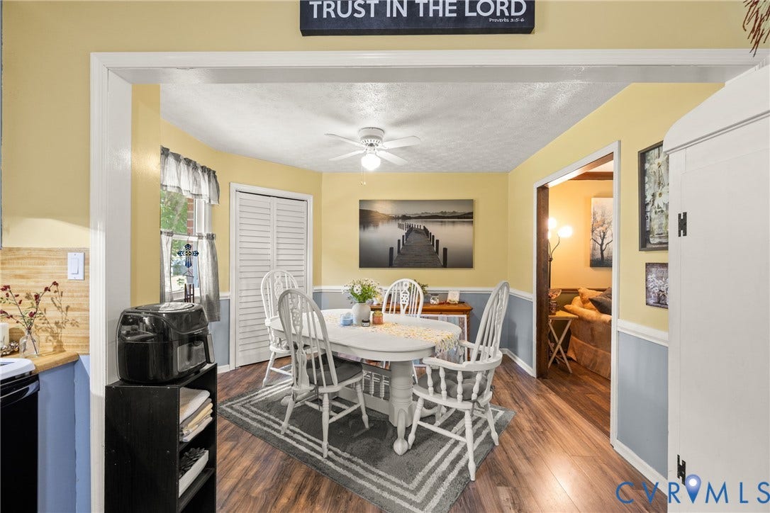 Wood-finish flooring throughout, light-toned wall paneling, and a ceiling fan with integrated lighting