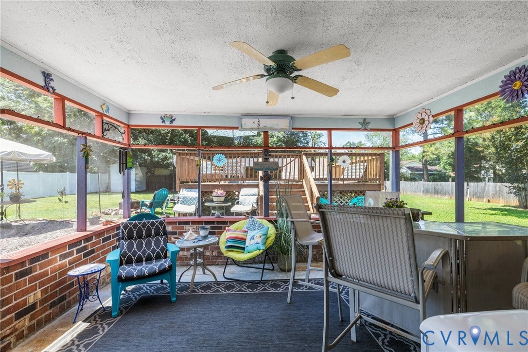 Screened porch featuring brick knee-walls, a ceiling fan, and an integrated mini-split system