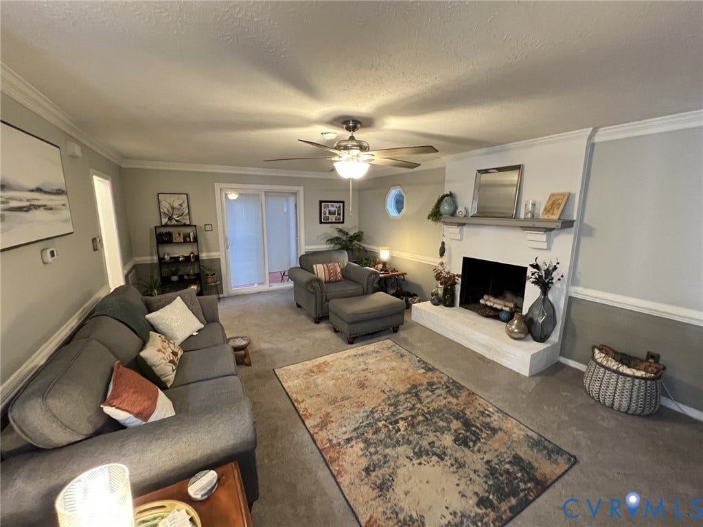 8336 Devils Den Lane, Mechanicsville, VA 23111 Recessed fireplace with hearth, crown molding, ceiling fan, and sliding glass door