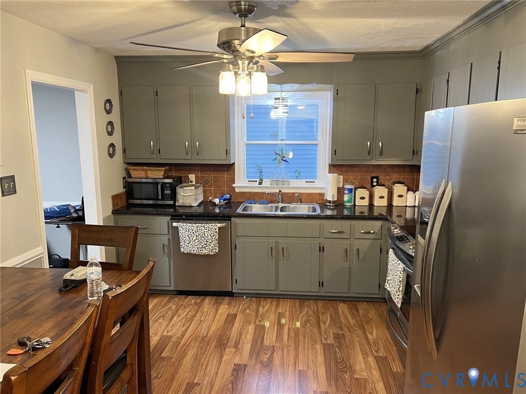 8336 Devils Den Lane, Mechanicsville, VA 23111 Kitchen featuring wood-finish flooring, dark countertops, tiled backsplash, and gray cabinetry
