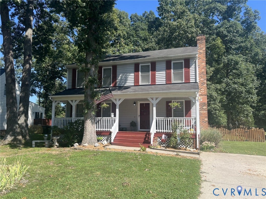 8336 Devils Den Lane, Mechanicsville, VA 23111 Two-story residence featuring siding exterior, a full-width covered porch, red shutters, and a prominent brick chimney