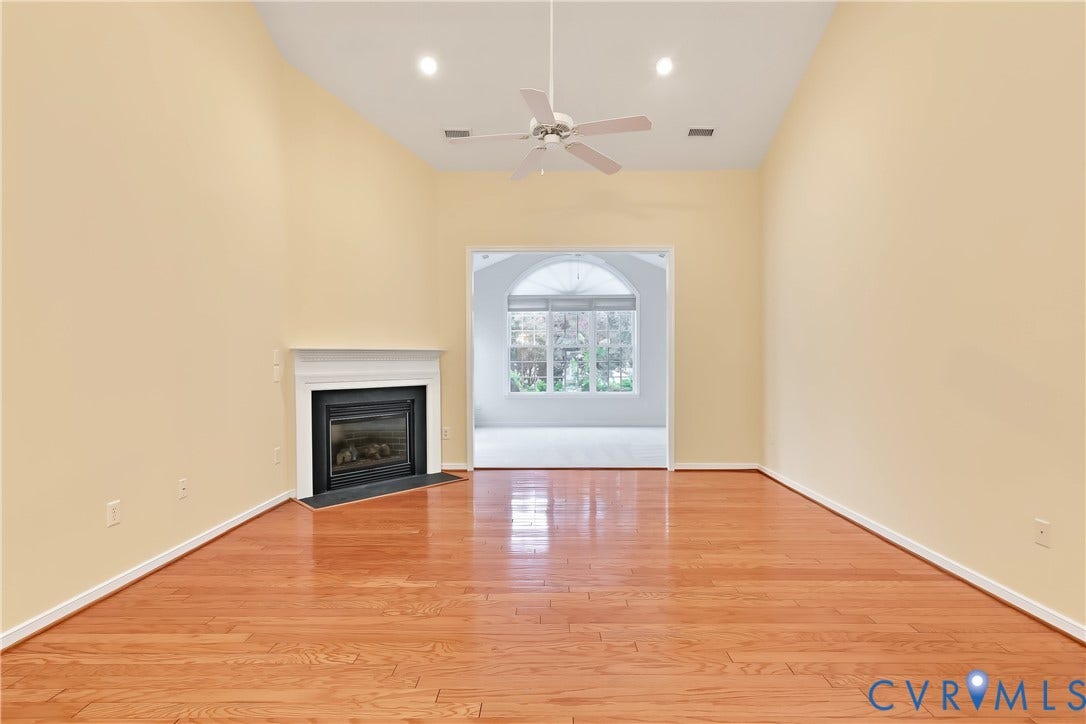 Large Living Room Featuring Engineered HW Floors, Gas Fireplace, Ceiling Fan, and Recessed Lighting.