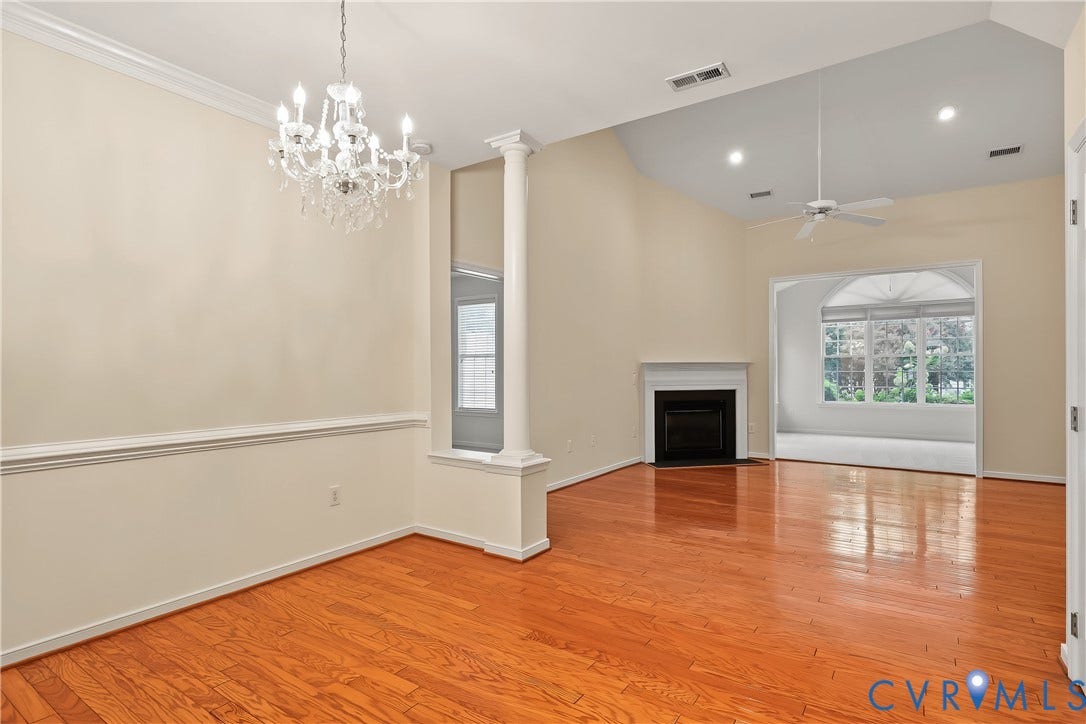 Formal Dining Room Featuring Engineered HW Floors, Chair Rail, Crown Molding, and Chandelier.