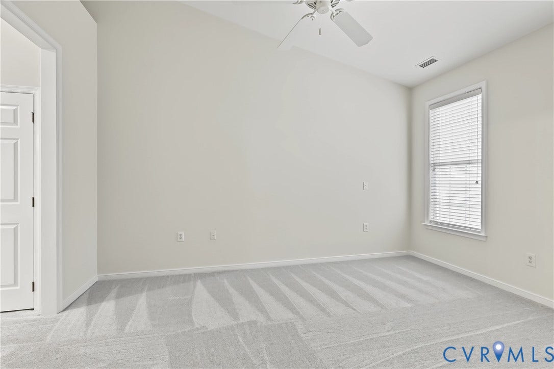 First Floor Primary Bedroom Featuring Carpet, Vaulted Ceiling, and Ceiling Fan.