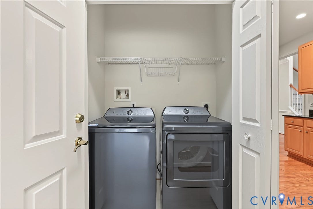 First Floor Laundry Area Featuring Washer/Dryer and Shelving for Extra Storage.