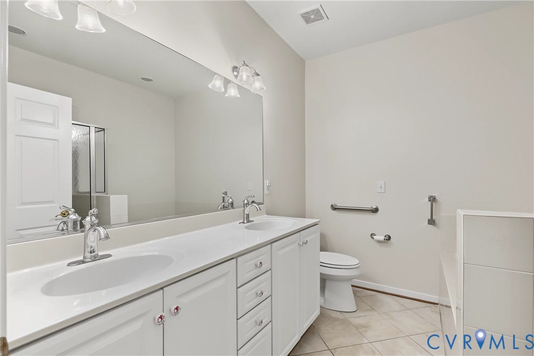 Primary Bathroom Featuring Tile Flooring and Dual Vanity Sinks.