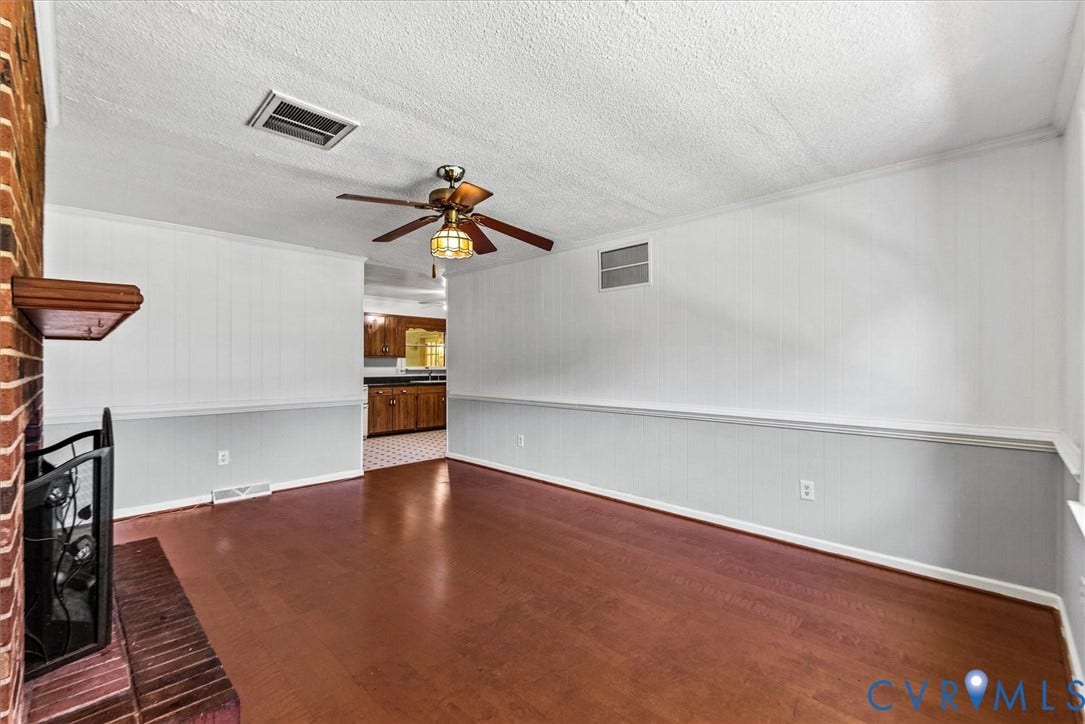 13012 Harrowgate Road, Chesterfield, VA 23831 Brick fireplace with a wood-finish mantel and a ceiling fan with integrated lighting