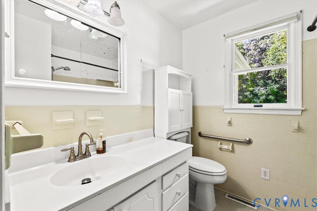 13012 Harrowgate Road, Chesterfield, VA 23831 White vanity with integrated sink, brushed nickel faucet, wall-mounted mirrored medicine cabinet, built-in storage cabinet, and tiled wainscoting
