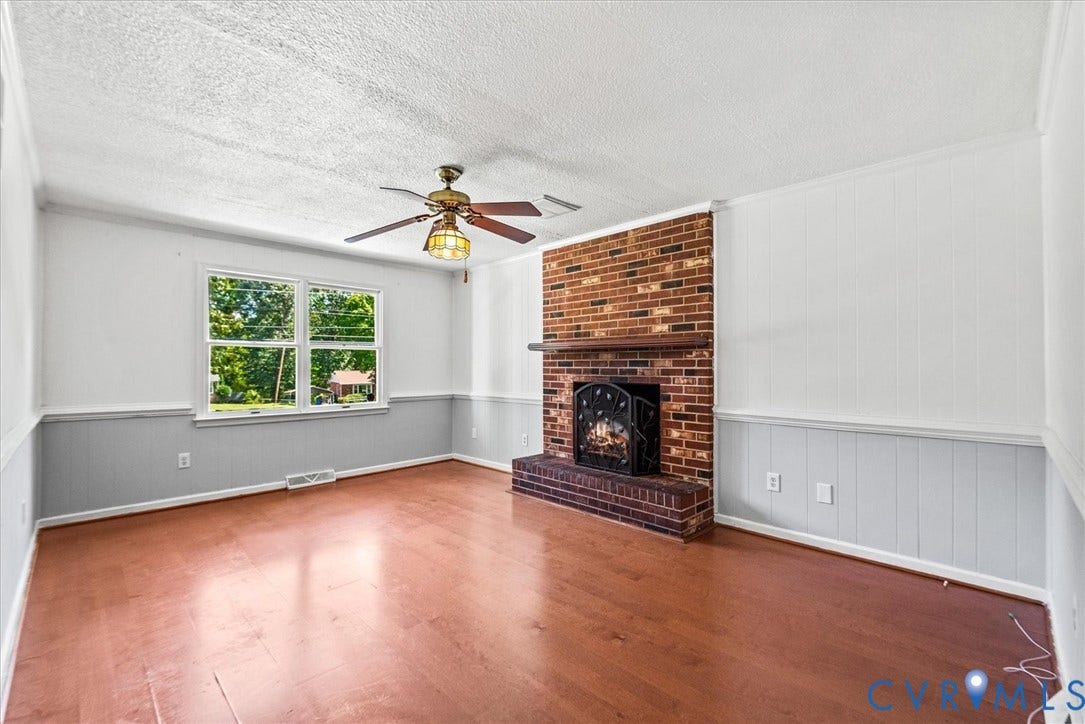13012 Harrowgate Road, Chesterfield, VA 23831 Brick fireplace with hearth, wood-finish flooring, ceiling fan, and two-tone wall paneling
