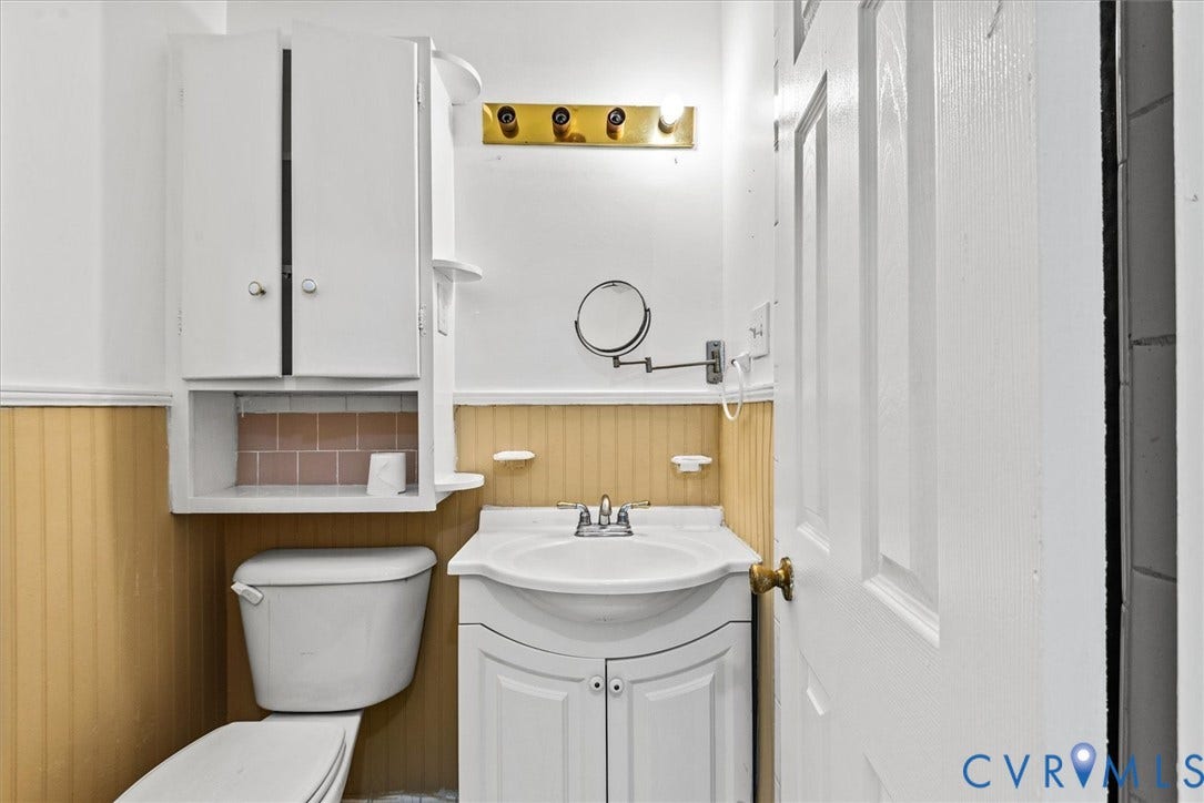 13012 Harrowgate Road, Chesterfield, VA 23831 White vanity with integrated sink, gold-finish light fixture, and wall-mounted storage cabinet