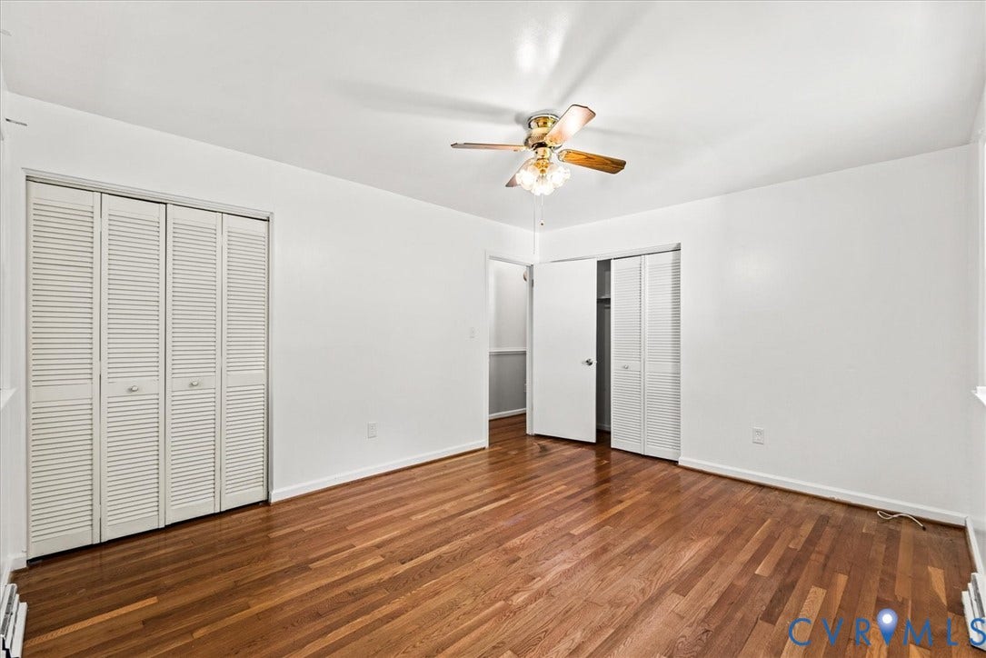 13012 Harrowgate Road, Chesterfield, VA 23831 Hardwood flooring, white walls, louvered bi-fold closet doors, and a ceiling fan with light fixture