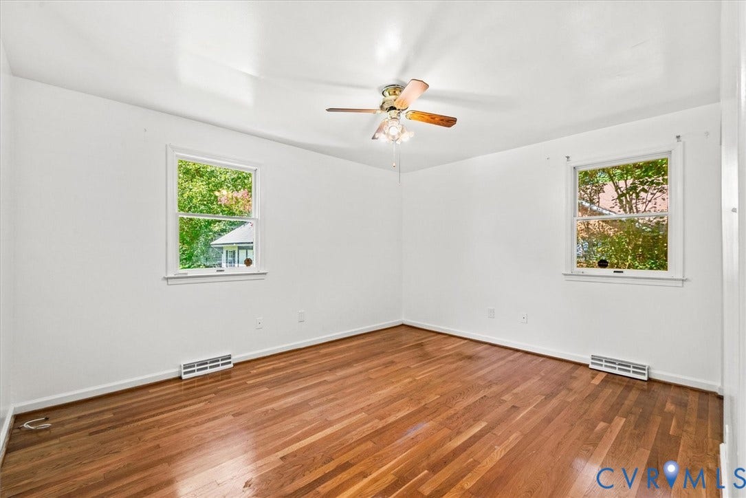 13012 Harrowgate Road, Chesterfield, VA 23831 Hardwood flooring, painted white walls, two windows with white trim, and a ceiling fan with light fixture