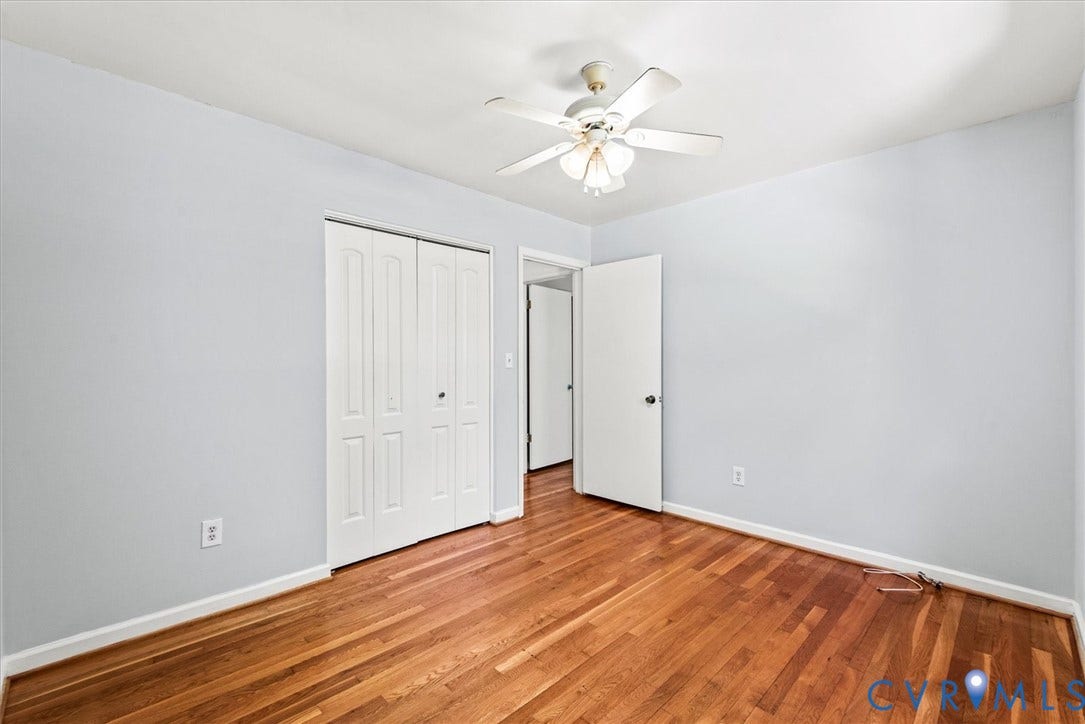 13012 Harrowgate Road, Chesterfield, VA 23831 Wood-finish flooring, light blue wall paint, white bi-fold closet doors, white ceiling fan with integrated lighting, and white trim