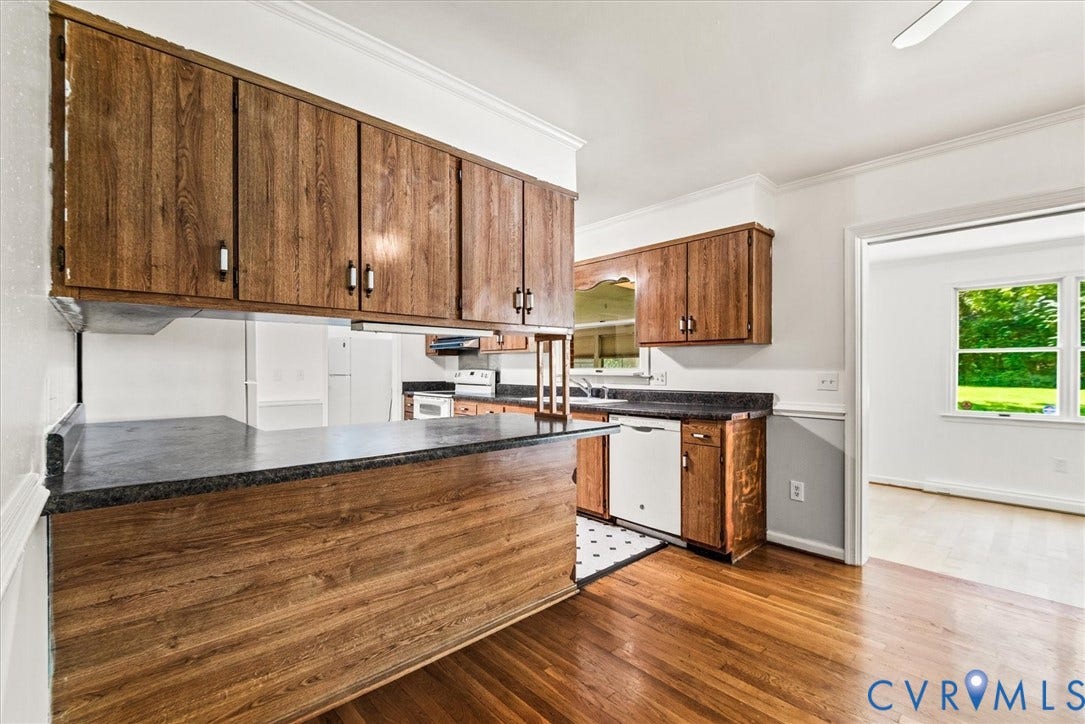 13012 Harrowgate Road, Chesterfield, VA 23831 Wood-finish cabinetry with dark hardware, dark countertops, wood-finish flooring, and white appliances