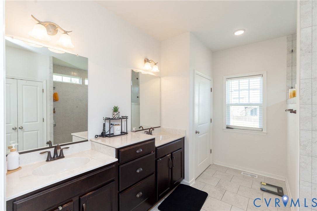 Dual vanities with integrated sinks, dark wood cabinetry, and contrasting light-toned countertops