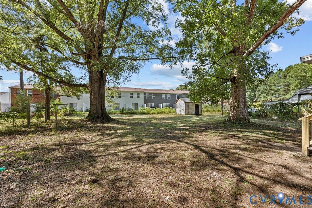 606 Effingham Drive, Woodhaven, Richmond, VA 23224 Expansive grassy area with mature shade trees and a storage shed