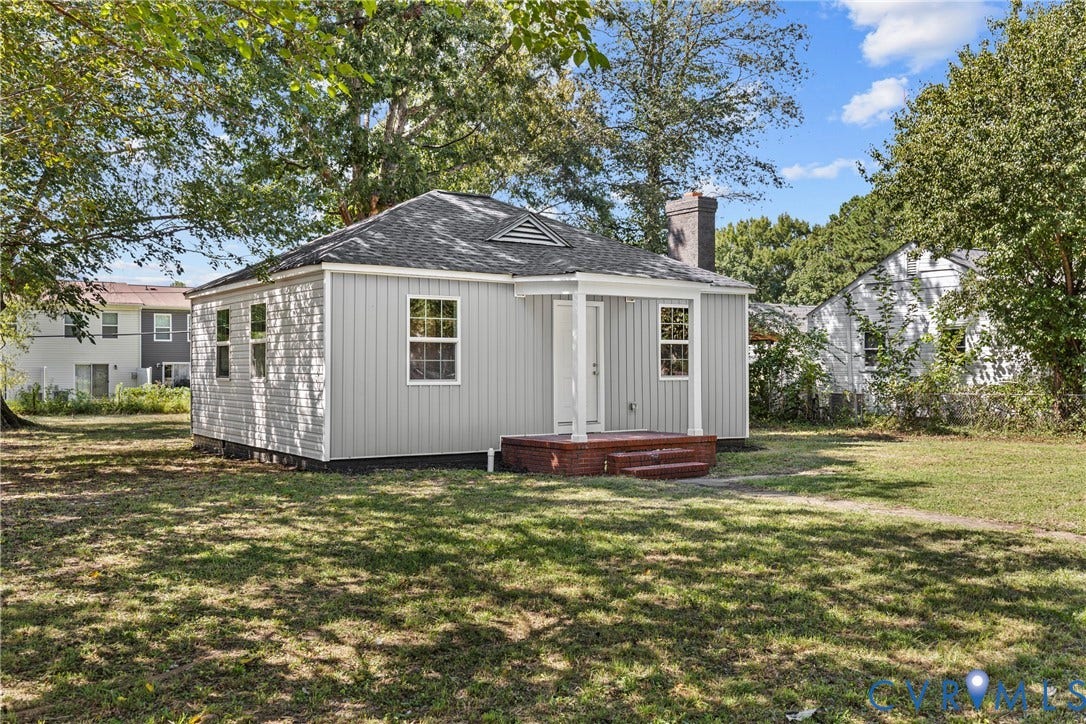 606 Effingham Drive, Woodhaven, Richmond, VA 23224 Single-story residence featuring light gray vertical siding, a dark shingle roof, and a prominent brick chimney