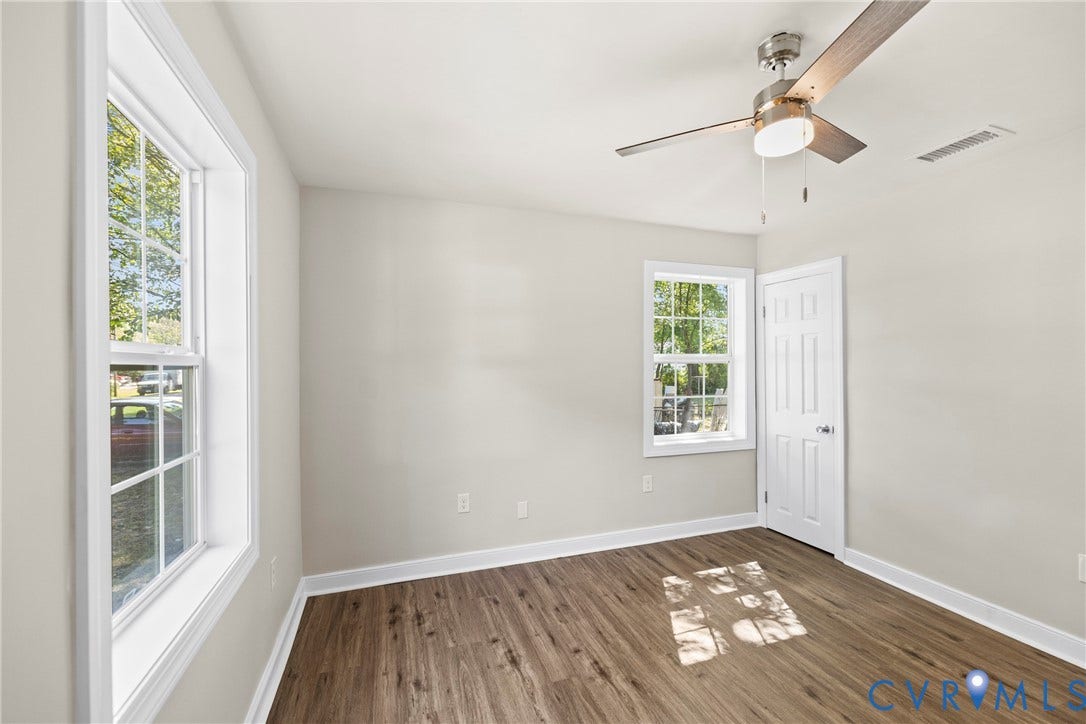 606 Effingham Drive, Woodhaven, Richmond, VA 23224 Wood-finish flooring, white paneled door, two double-hung windows, and a ceiling fan with integrated lighting