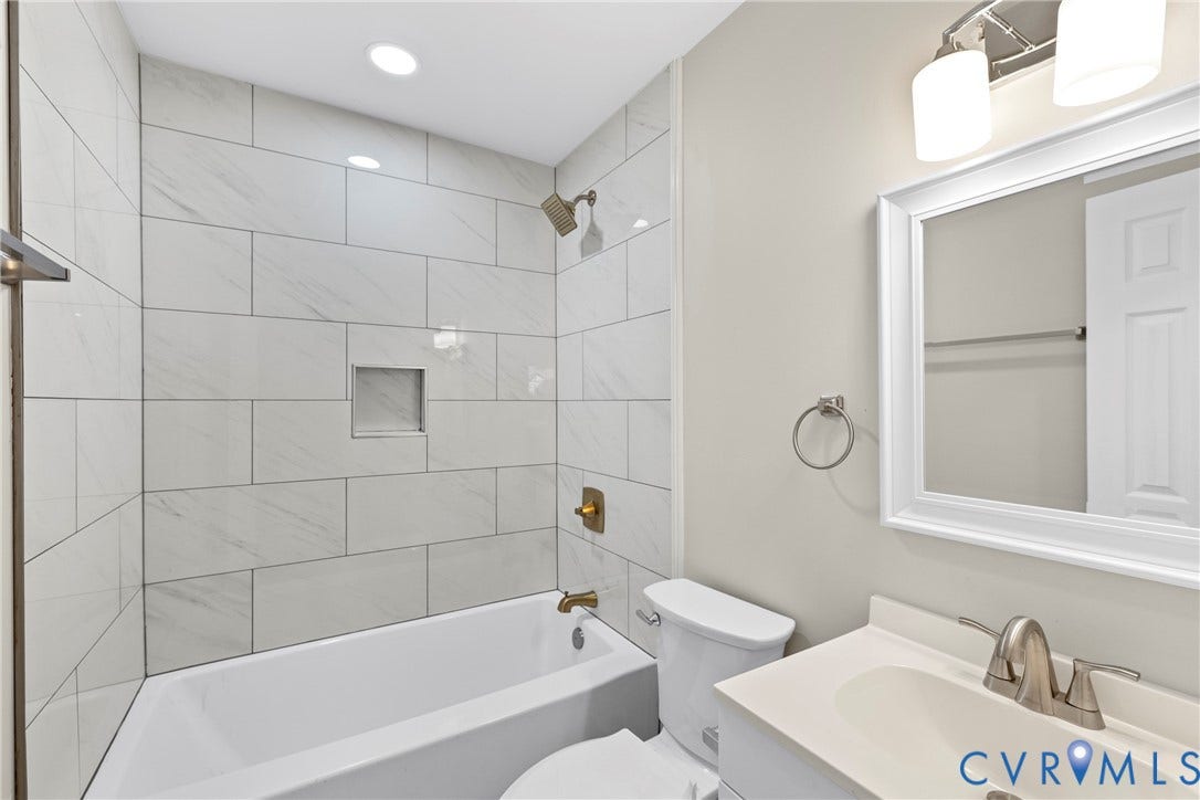 606 Effingham Drive, Woodhaven, Richmond, VA 23224 Bathtub with subway tile surround, recessed shower niche, and brass-finish fixtures