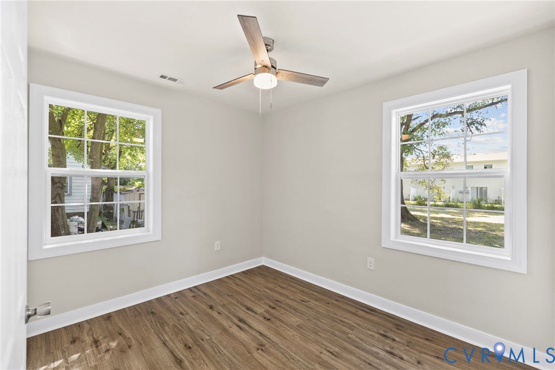 606 Effingham Drive, Woodhaven, Richmond, VA 23224 Neutral wall color, wood-finish flooring, two large windows, ceiling fan with integrated lighting