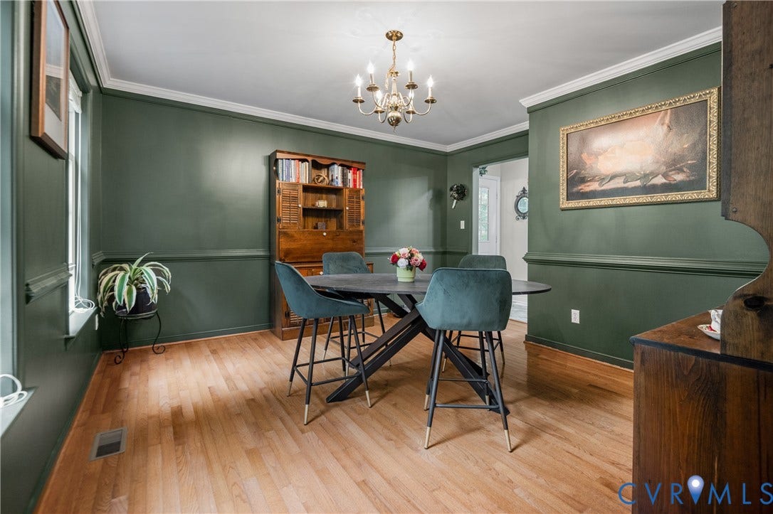 Hardwood flooring, painted walls with chair rail, and crown molding