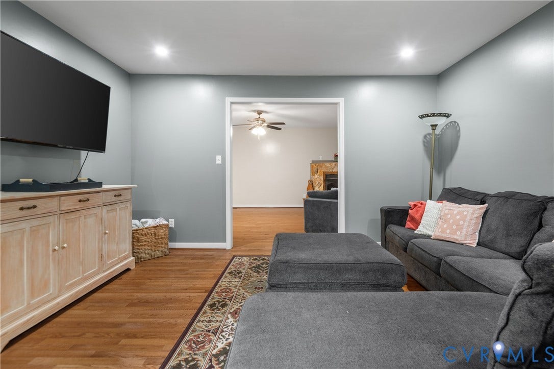 Recessed ceiling lighting illuminates the living area with wood-finish flooring