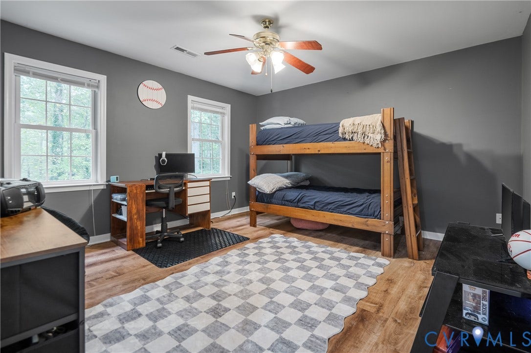 Recessed lighting, wood-finish flooring, and two windows with white trim