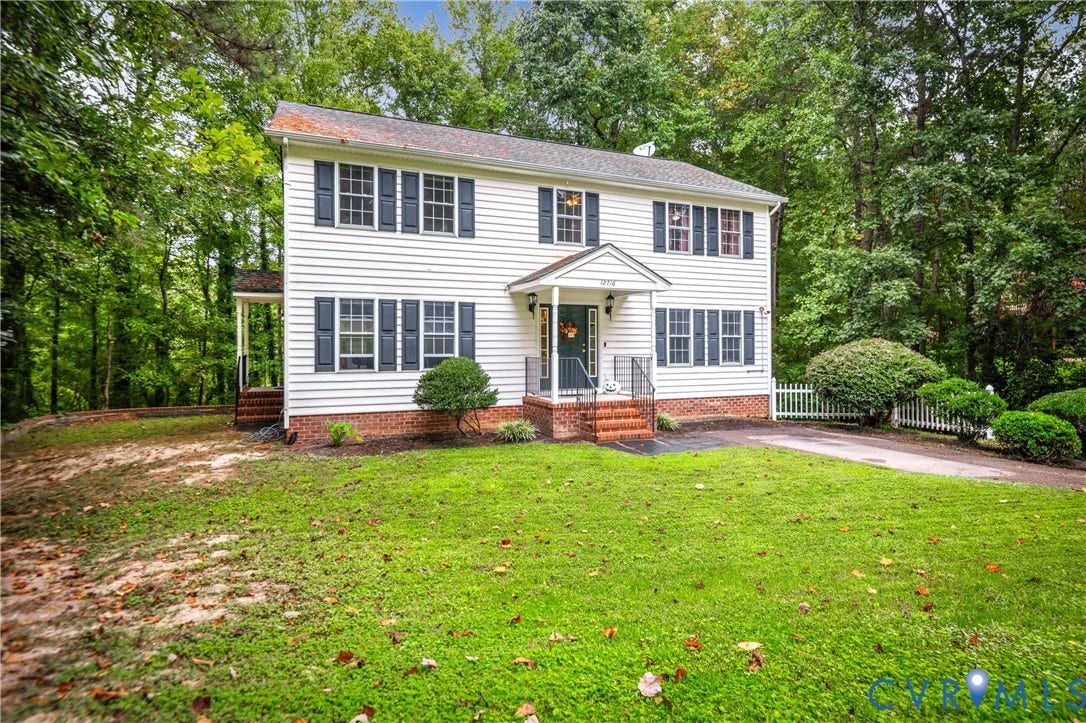 Traditional two-story residence with white siding and dark shutters