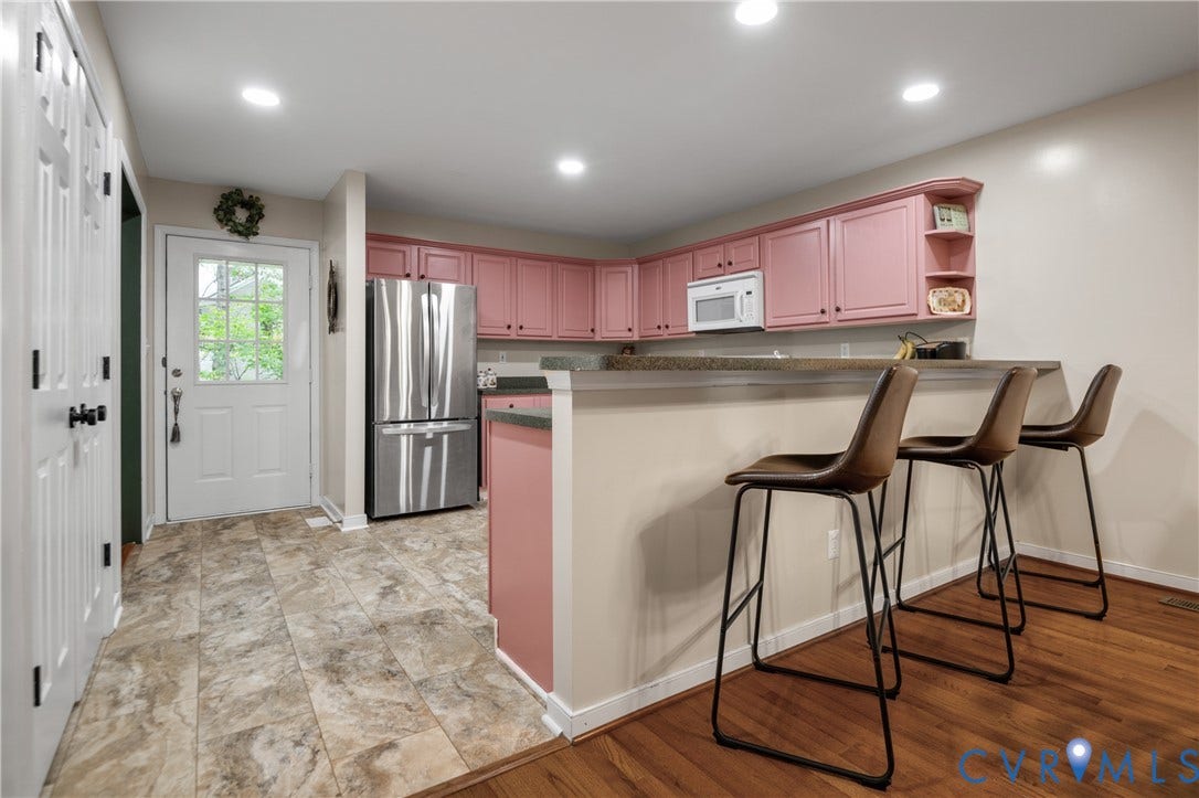 Kitchen featuring painted cabinetry, stainless steel refrigerator, built-in microwave, and recessed lighting