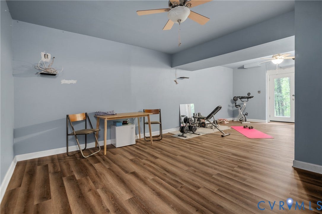 Wood-finish flooring throughout, paired with a ceiling fan with integrated lighting