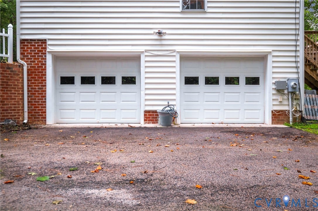 Two white panel-style garage doors with window inserts
