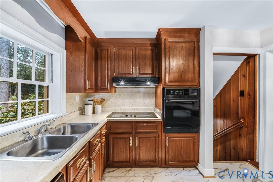 7548 Piney Branch Road, Stratford Hills, Richmond, VA 23225 Wood cabinetry with brass hardware, double basin stainless steel sink, built-in wall oven, electric cooktop, and white tiled flooring