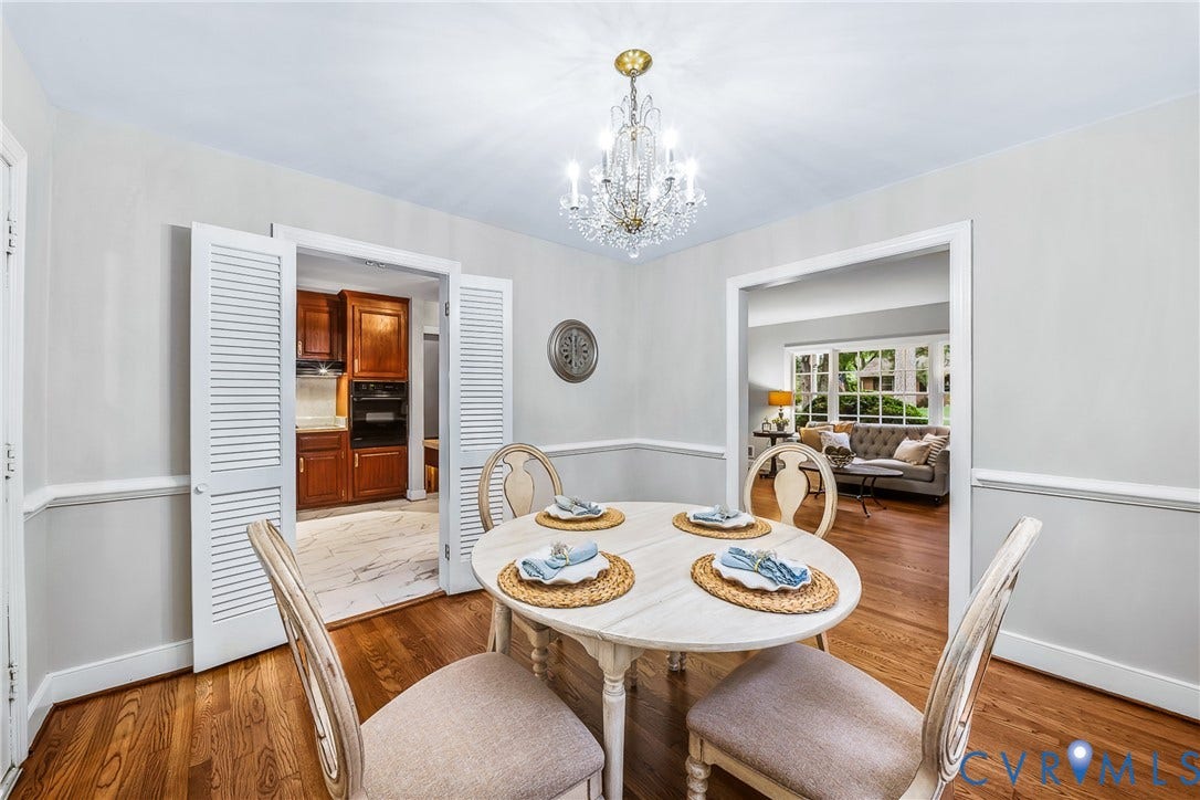 7548 Piney Branch Road, Stratford Hills, Richmond, VA 23225 Hardwood flooring, crystal chandelier, decorative wall trim, louvered bi-fold doors, and recessed wall opening