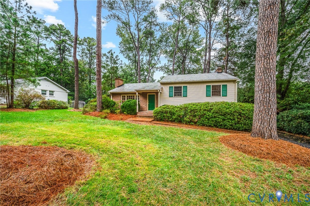 7548 Piney Branch Road, Stratford Hills, Richmond, VA 23225 Brick and siding exterior with green shutters, surrounded by mature trees, and a spacious lawn with established landscaping