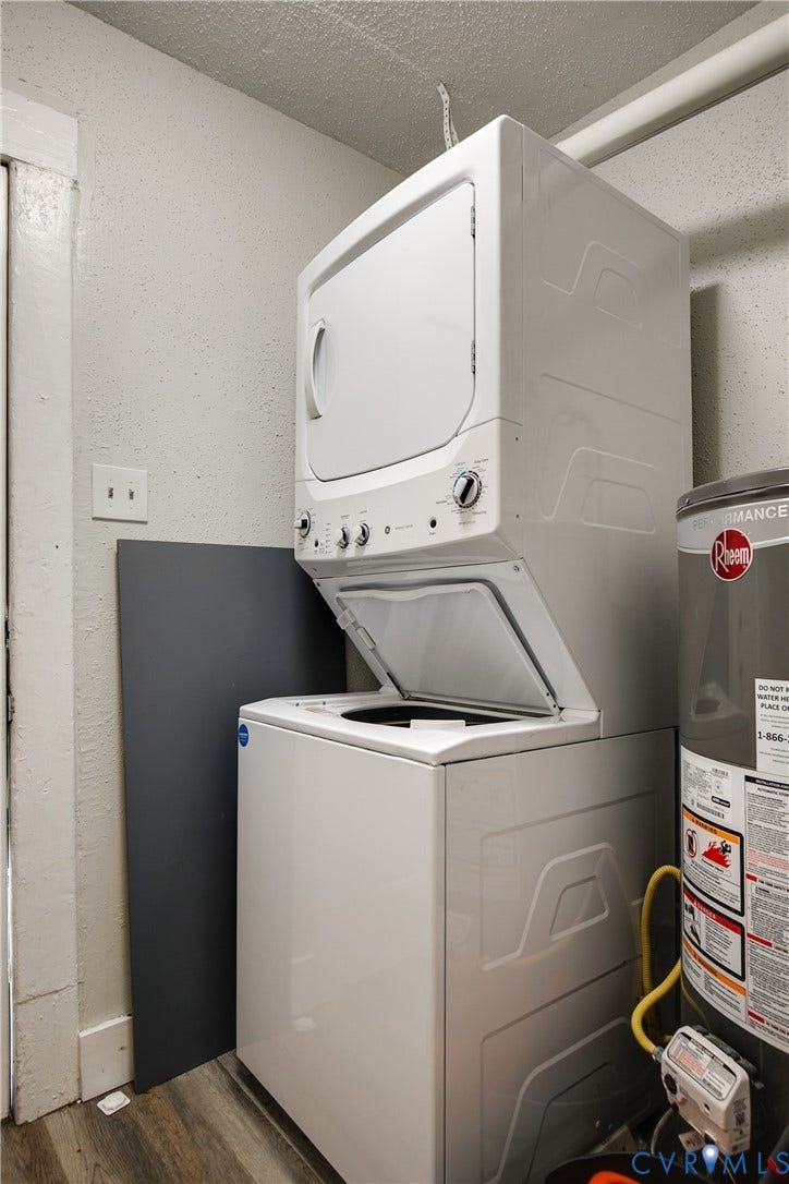 3314 3rd Avenue, Northside, Richmond, VA 23222 Stacked white washer and dryer unit, water heater, and wood-finish flooring
