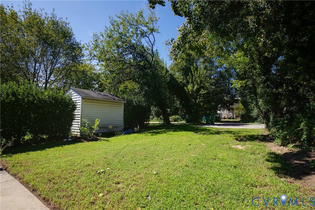 3314 3rd Avenue, Northside, Richmond, VA 23222 Detached storage shed with siding exterior, situated on a grassy lot with mature trees and established shrubbery