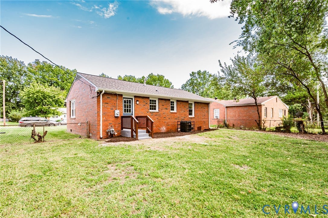 1608 Bryan Street, Richmond, VA 23223 Brick exterior with white trim, dark shingle roof, and a wood-finish staircase with handrails