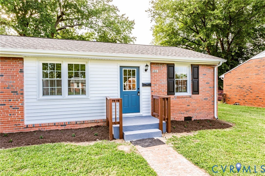 1608 Bryan Street, Richmond, VA 23223 Brick and siding exterior with a contrasting blue door, white-framed windows, and a shingle roof