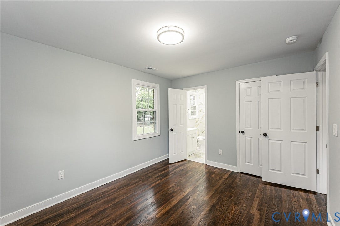 1608 Bryan Street, Richmond, VA 23223 Hardwood-finish flooring, light gray wall color, white trim, single window, and a built-in closet with white paneled doors