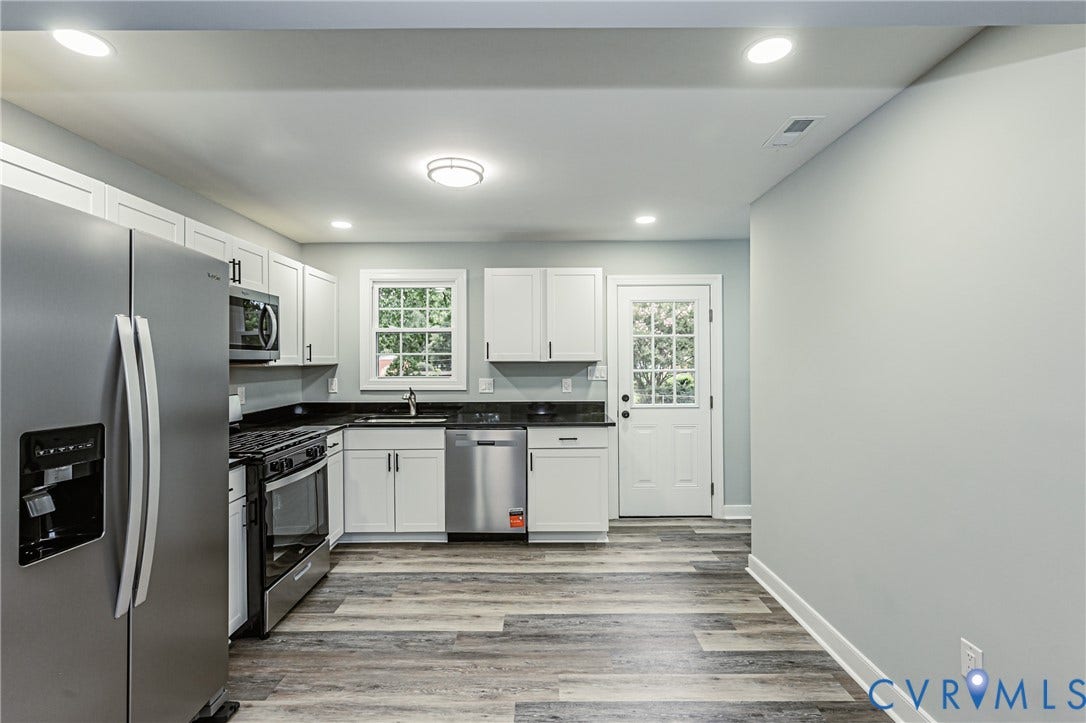 1608 Bryan Street, Richmond, VA 23223 Kitchen featuring wood-finish flooring, white cabinetry, dark countertops, and stainless steel appliances